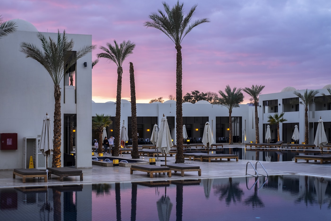 Dramatic hotel lobby with warm candlelit lighting and dark sandstone surfaces