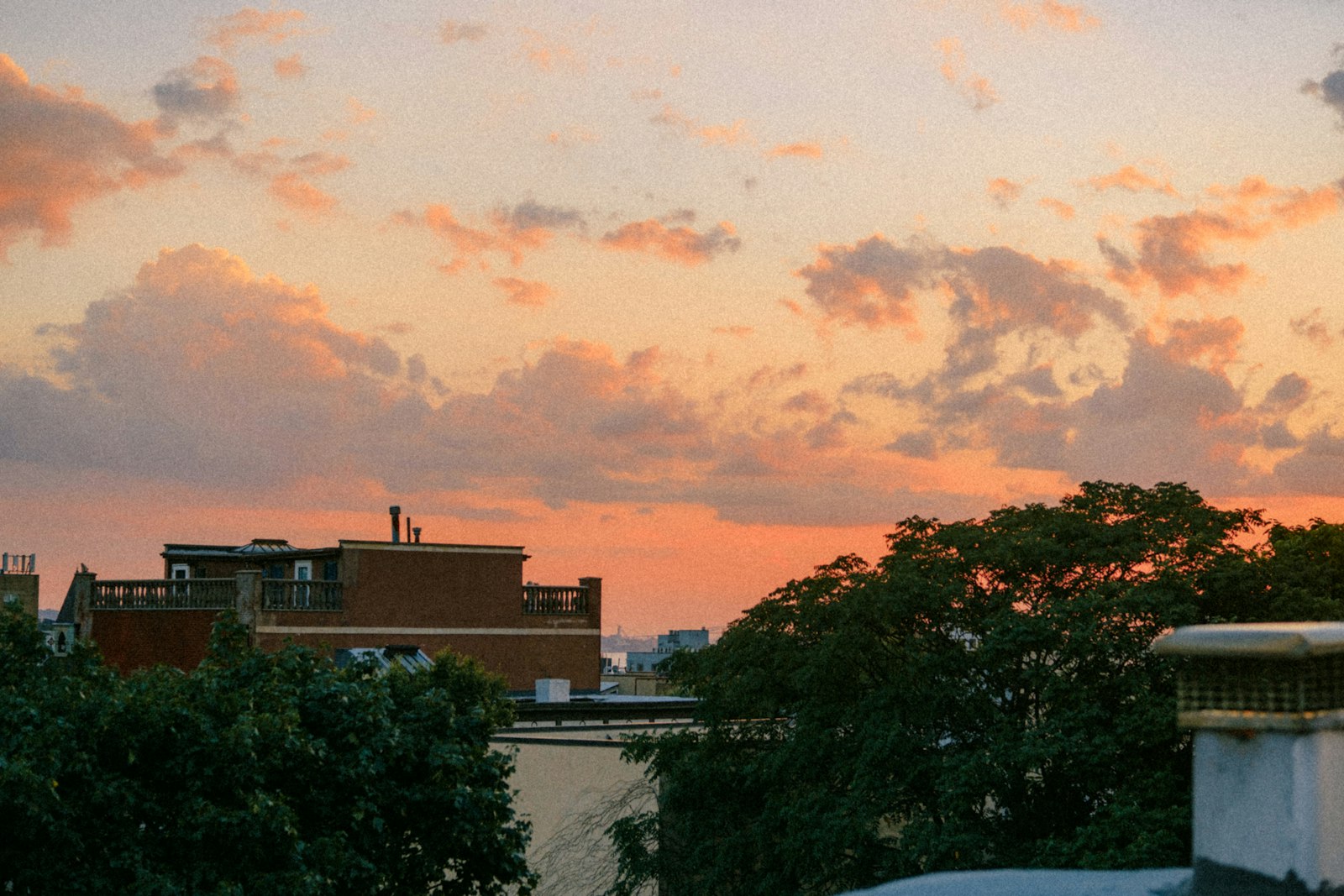 Rooftop terrace at sunset with lounge seating and dramatic orange sky